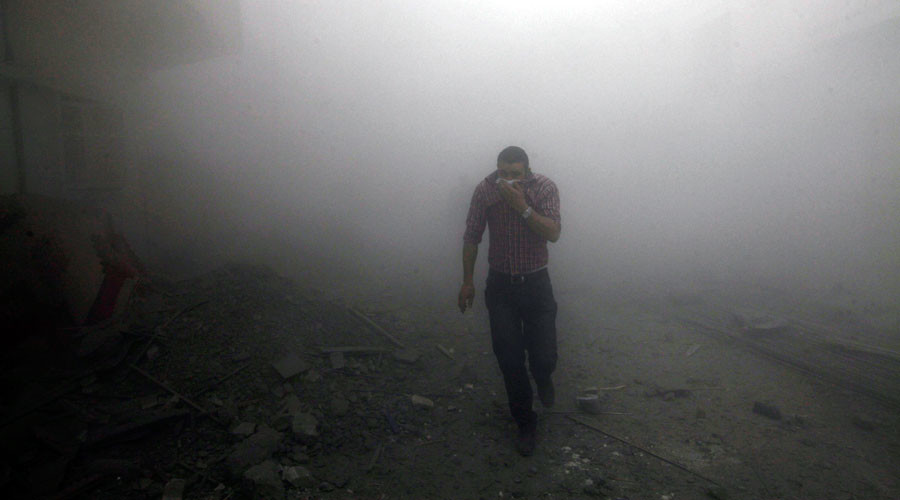 Un hombre escapa de una nube de humo provocada por un ataque aéreo de la Coalición Internacional liderada por EEUU en Raqqa (Siria)
